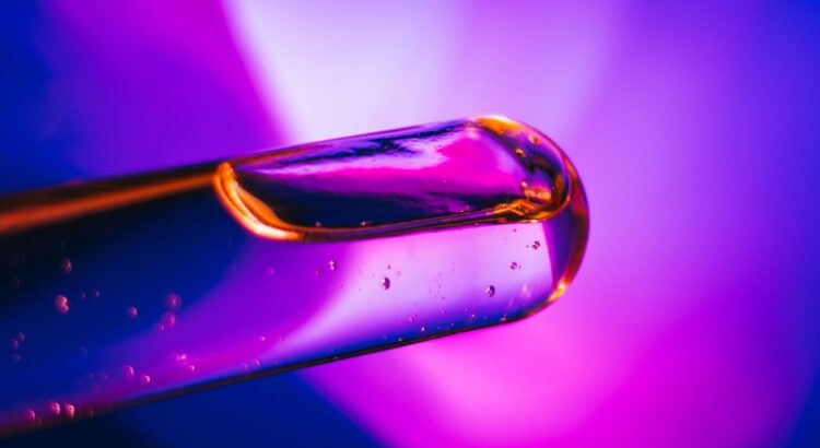 Close-up of a reflective glass surface with vivid purple and blue lighting