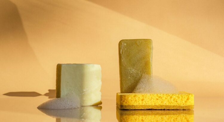 Solid cosmetic bars and a sponge arranged on a reflective surface